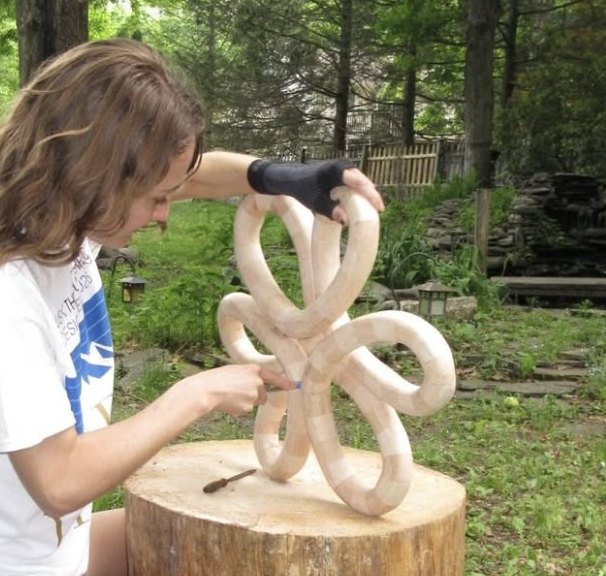 Lauren Lauer shaping a wood sculpture by hand